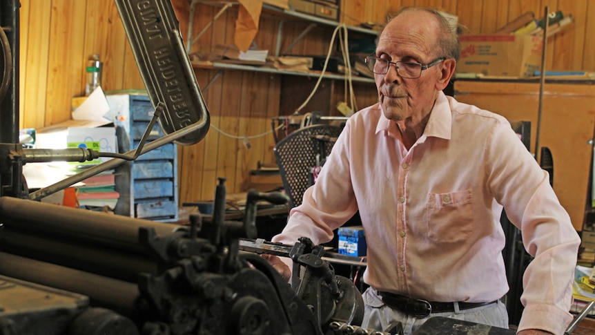 Hillston Spectator editor Patrick O'Sullivan standing next an old printing device