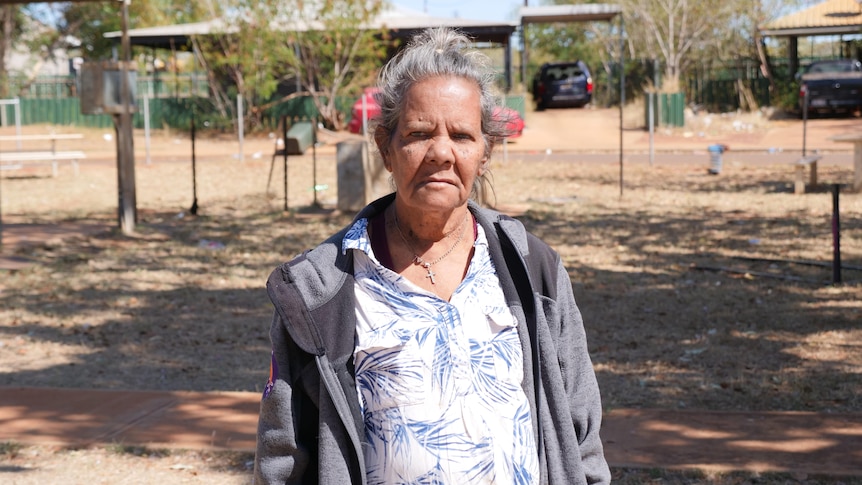 an Indigenous woman stands in a park