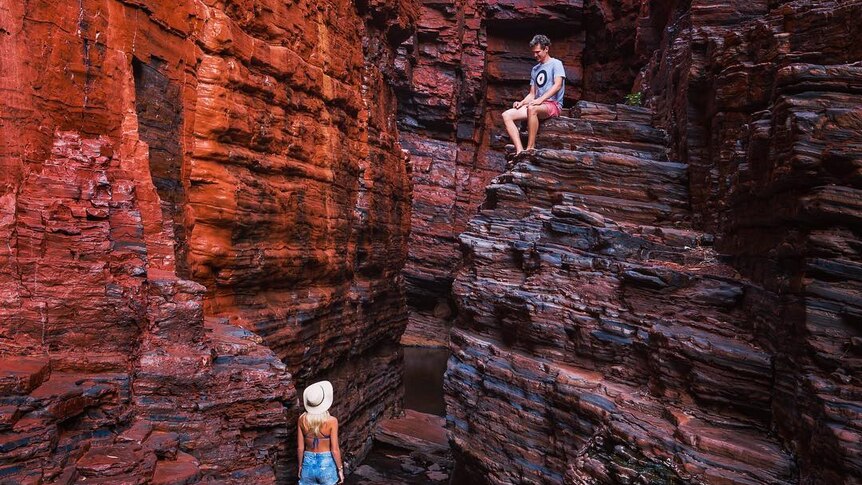 Two people in a red-rock gorge