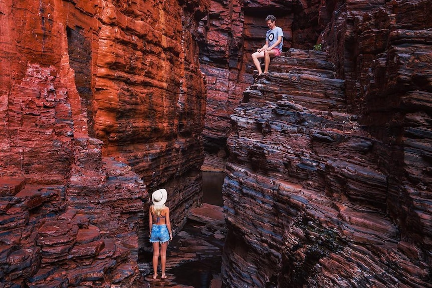 Two people in a red-rock gorge