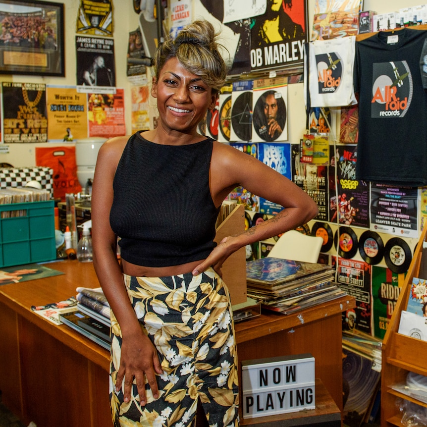 Dinushi Dias standing in a record store and smiling.