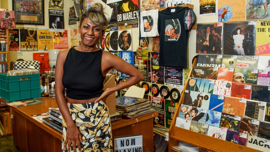 Dinushi Dias standing in a record store and smiling.