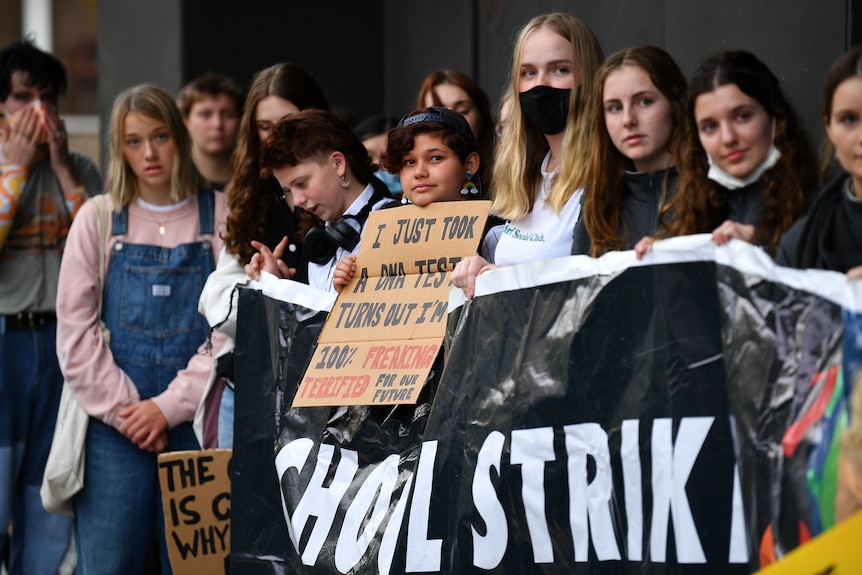 High school students gather with protest signs about climate change