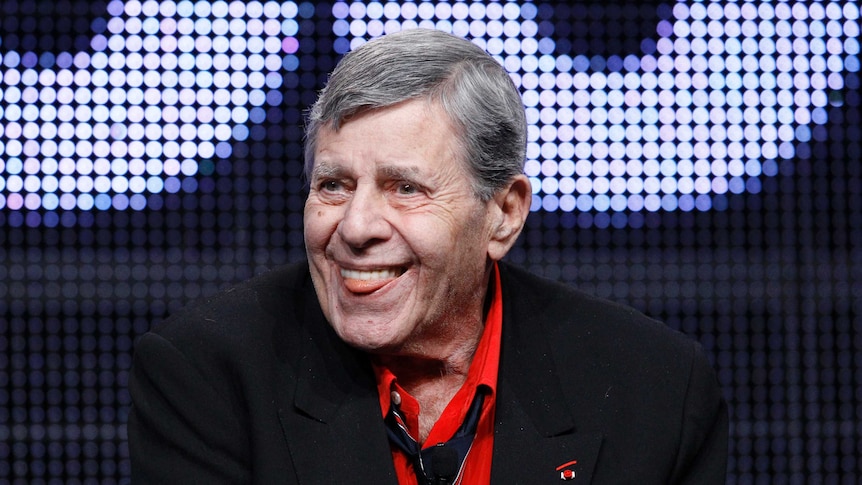 Actor and comedian Jerry Lewis smiles with his tongue out.