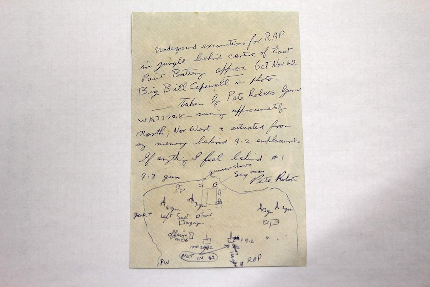 A photo of the reverse side of an archival photo, which has a note written on it.