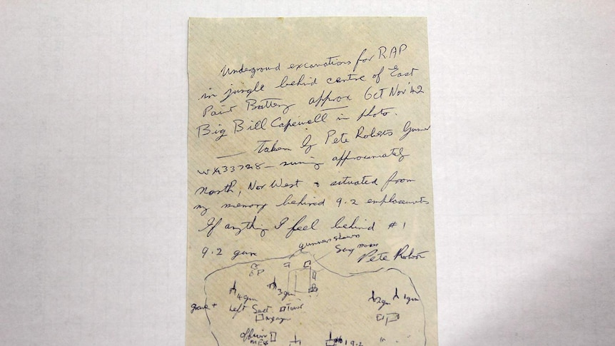 A photo of the reverse side of an archival photo, which has a note written on it.