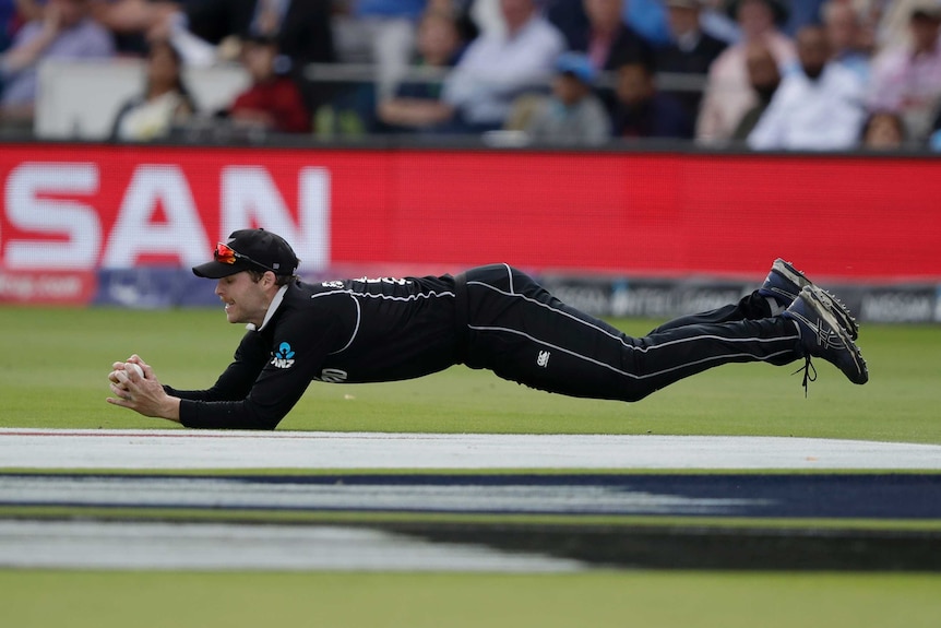 Lockie Ferguson dives forward to take a catch in the Cricket World Cup final between New Zealand and England.