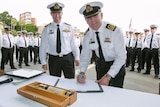 Former HMAS Success Commanding Officer Captain Justin Jones with successor Commander Michael Letts in military uniform.