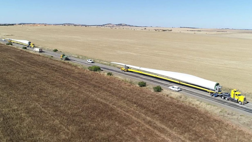 An aerial shot of two trucks carrying two wind turbine blades along the Barrier Highway.