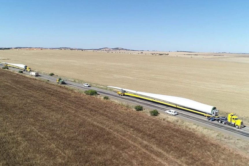 An aerial shot of two trucks carrying two wind turbine blades along the Barrier Highway.