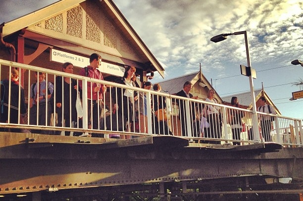 Passengers wait on the overhead bridge amid train delays at Gordon station in Sydney.