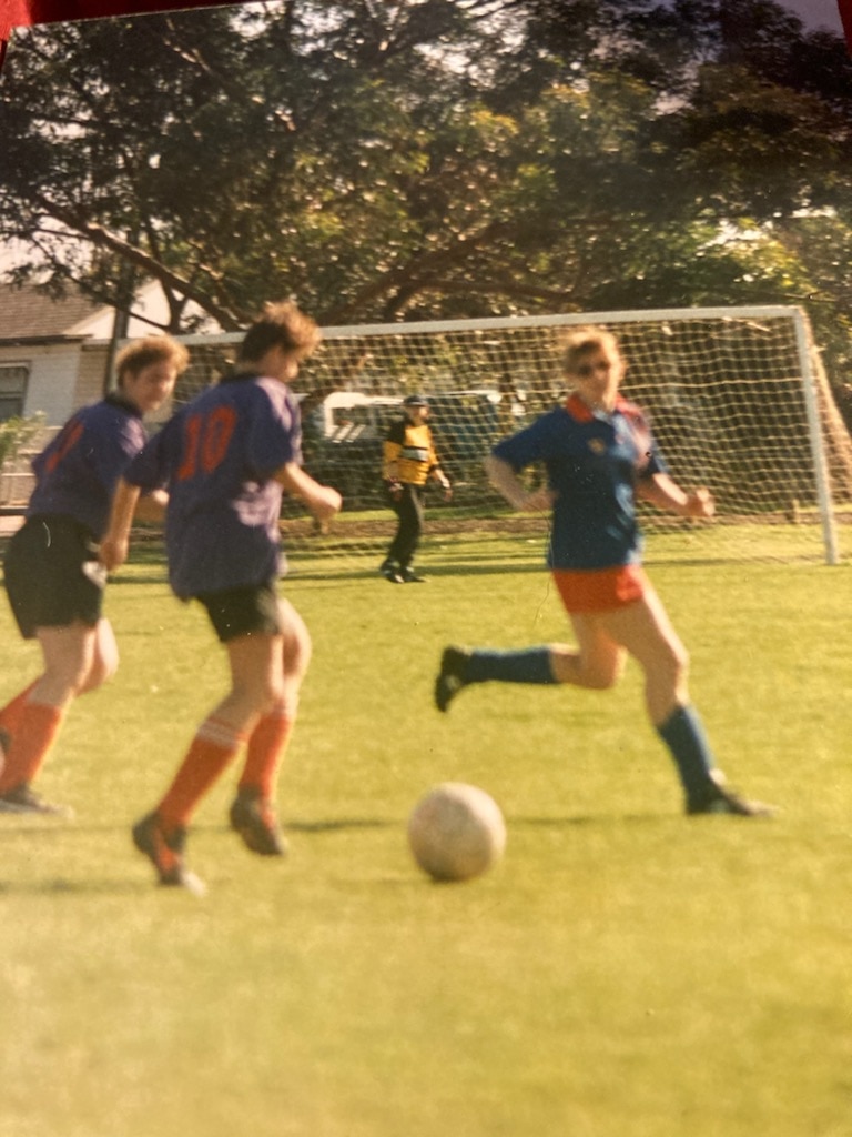 Women soccer players wearing purple and blue jerseys during a match