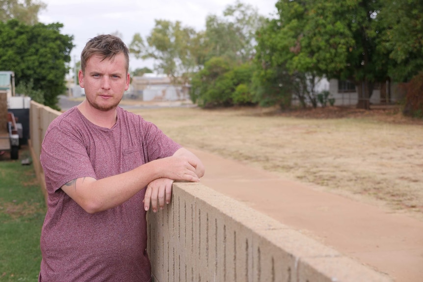 Man leaning against fence