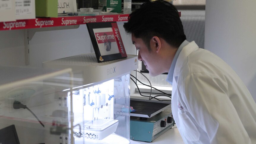 Dr Joshua Chou looking at a piece of scientific equipment in his lab at the UTS