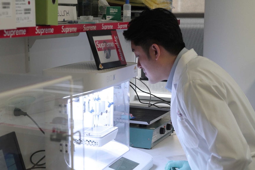 Dr Joshua Chou looking at a piece of scientific equipment in his lab at the UTS