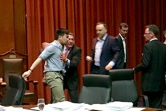 Man being restrained at a Yarraville council meeting in a dispute over parking meters.