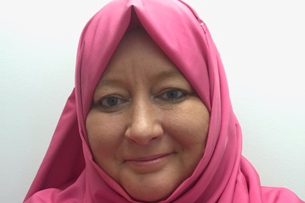 A head shot of Rania Shafiq wearing a pink hijab and smiling.