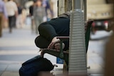 A homeless person sleeping on bench in the Brisbane CBD
