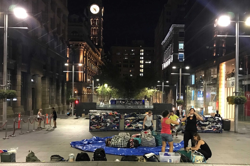 War on Waste production team building a fashion pile in Martin Place, Sydney at night.