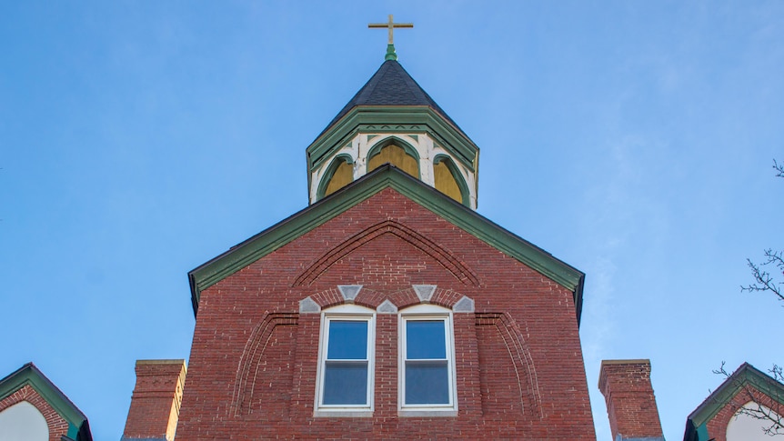 low camera angle, brick building with Christian cross on top