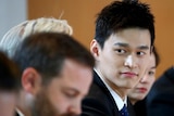 Chinese swimmer Sun Yang dressed in a suit for a public hearing.