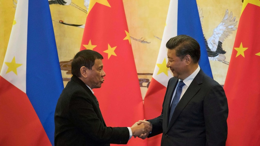 Rodrigo Duterte (L) and Chinese President Xi Jinping shake hands after a signing ceremony.