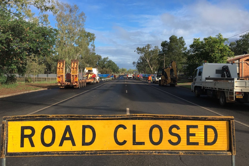A road closed sign and council trucks in front of the levee at Charleville