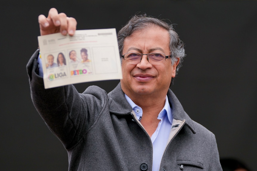 Colombia's president Gustav Petro holding a ballot paper in his hand 