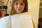 Little girl holding note saying Coronacast is boring.