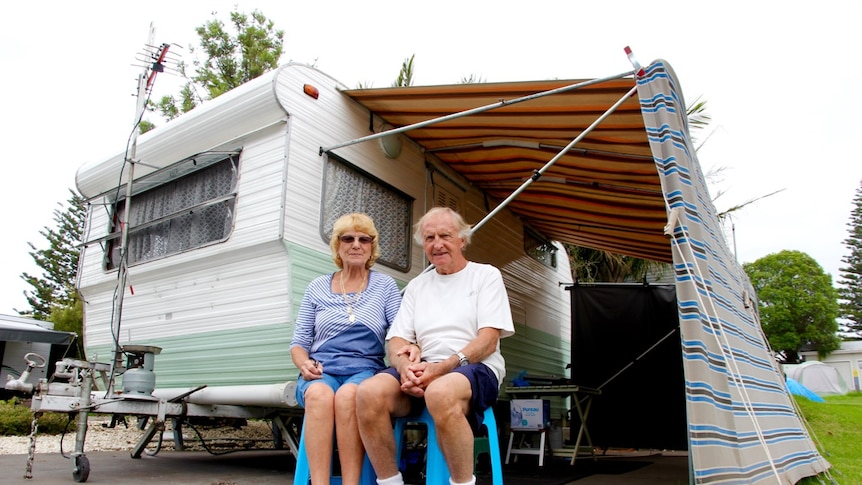 Two retirees, Ray and Annie Barrow, sit in front of their 1960s retro caravan