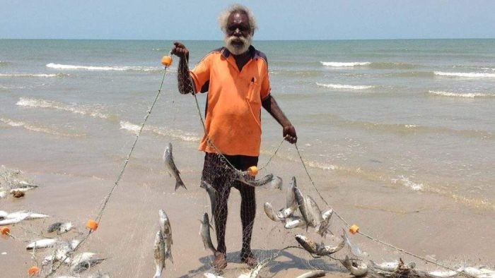 A man holds fish in a net