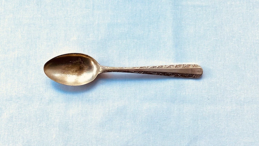 A silver spoon that is worn down with age and use.