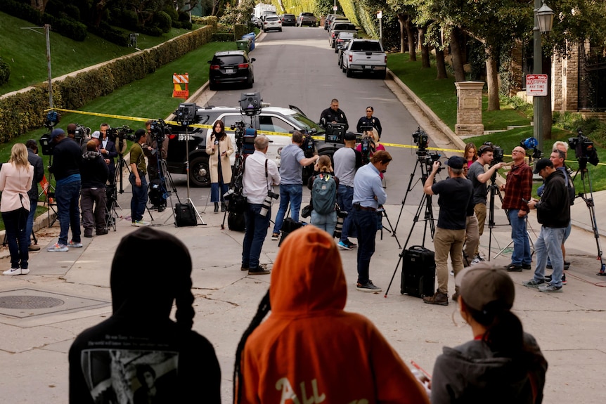 Camera crews and onlookers outside a Los Angeles home