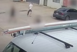 Man stalks around carpark holding gun in grainy CCTV still
