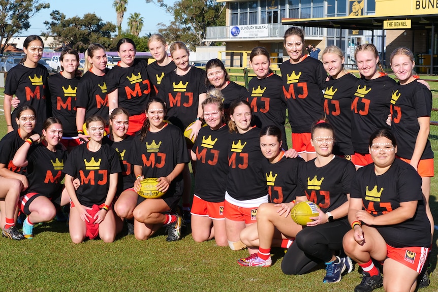 Un grupo de mujeres posan para una foto en un campo de fútbol