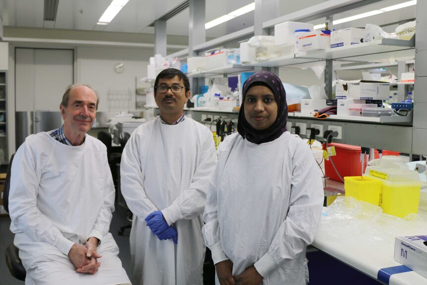 Professor Roger Smith sits in a lab with his colleagues Kaushik Maiti and Zakia Sultana