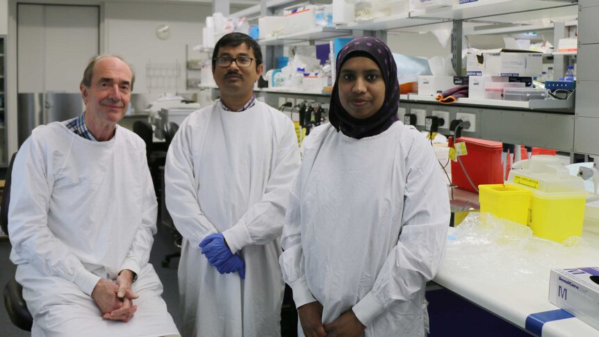 Professor Roger Smith sits in a lab with his colleagues Kaushik Maiti and Zakia Sultana
