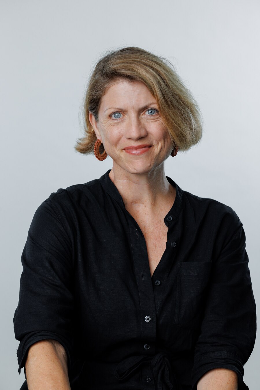 A head shot of a blonde middle-aged white woman wearing a black shirt and smiling.