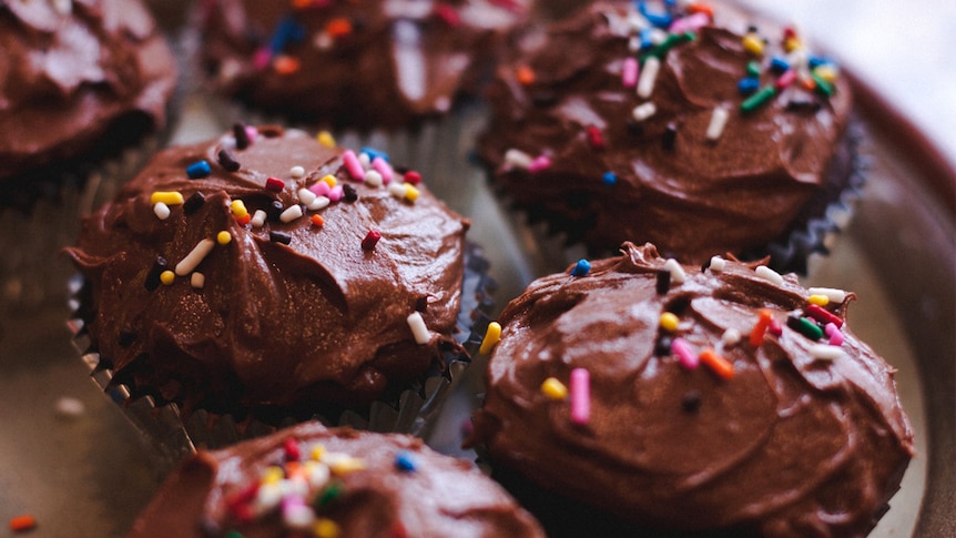 Iced chocolate cupcakes with sprinkles.