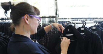 A woman checks a label on a jacket.