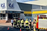 firefighters standing outside an Ice Arena building.