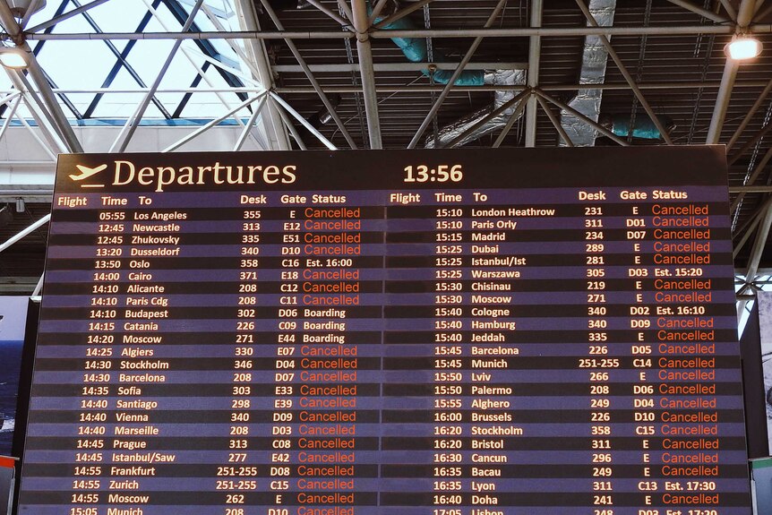 A departures board in an airport shows the majority of flights have been cancelled.