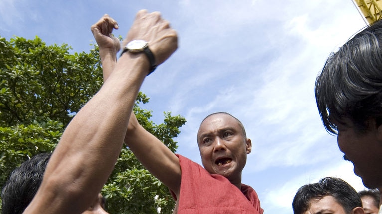 Defiance: A monk is lifted in the air by a crowd chanting anti-government slogans in Rangoon city centre
