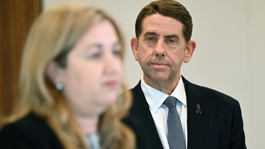 Queensland Treasurer Cameron Dick (right) looks on as Premier Annastacia Palaszczuk (left) addresses a press conference