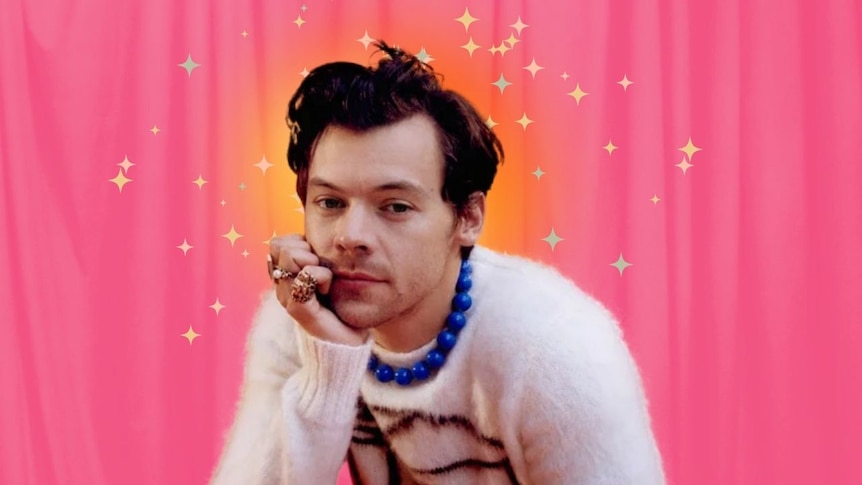Harry Styles wearing a jumper and rings, looking at the camera.