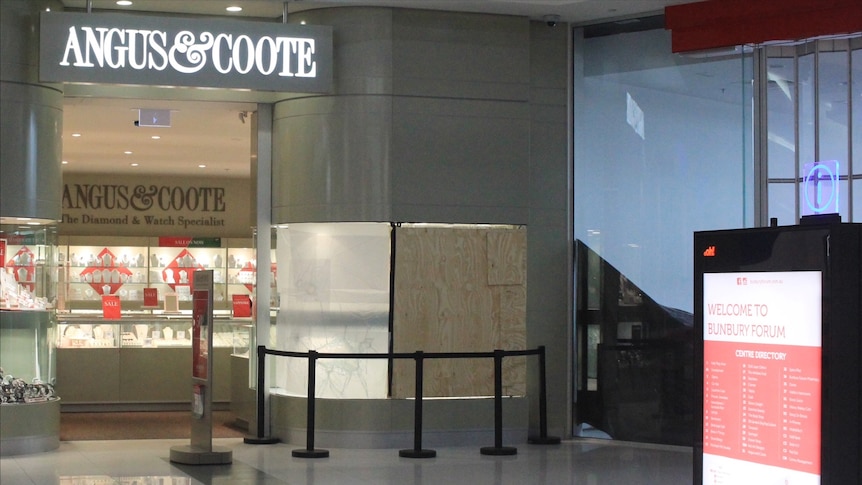 A jewelry shop with Angus and Coote on sign, one window boarded up