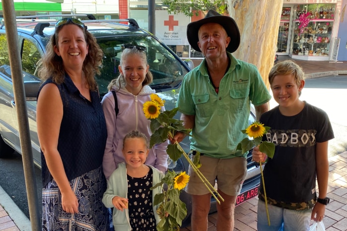 The family poses with their sunflowers and John Tidy.