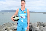 Female basketball player standing on shoreline for promotional shot holding basketball