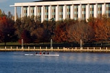 The National Library of Australia on the shores of Lake Burley Griffin, with rowers in the foreground  