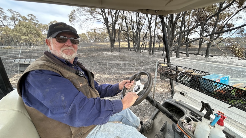 A man driving a golf buggy with burnt ground behind